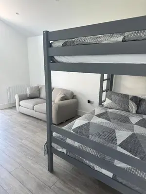 a bedroom with a bunk bed and a couch at Rural Retreats 8 in Southminster
