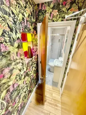 a bathroom with a flowery wallpaper on the wall at Beautiful city centre studio - central location in Cambridge