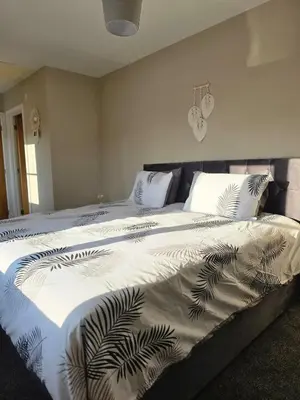 a bedroom with a large bed with white blankets and pillows at Spacious & Homely Colchester Stay-Great Location in Hythe