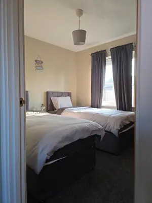 a bedroom with two beds and a window at Spacious & Homely Colchester Stay-Great Location in Hythe