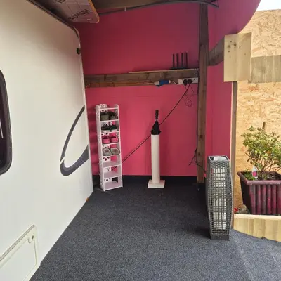 a room with a pink wall and a shelf at The Cosy Hide - A romantic rural retreat for 2 in Cottenham