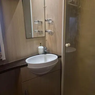 a bathroom with a white sink and a mirror at The Cosy Hide - A romantic rural retreat for 2 in Cottenham