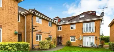 a large orange brick house with a yard at Penthouse with amazing view in Romford