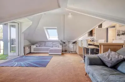 a living room with a couch and a table in a house at Penthouse with amazing view in Romford