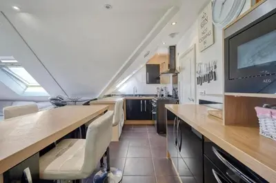 a kitchen with a table and a tv in a room at Penthouse with amazing view in Romford