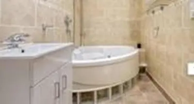 a bathroom with a white tub and a sink at Penthouse with amazing view in Romford