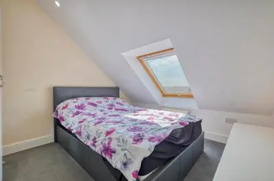 a small bed in a room with a window at Penthouse with amazing view in Romford