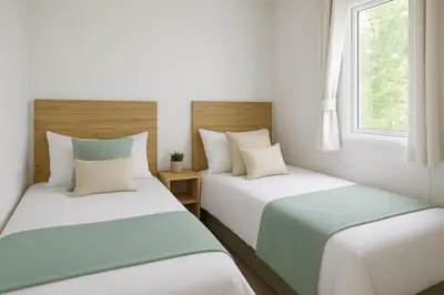 two beds in a room with white and green at Morsh Luxury Caravan Getaway in Colchester