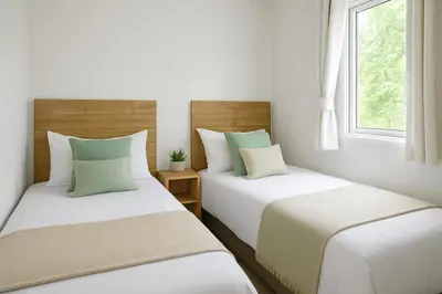 two beds in a room with white walls and a window at Morsh Luxury Caravan Getaway in Colchester