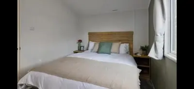 a bedroom with a white bed with a wooden headboard at Morsh Luxury Caravan Getaway in Colchester