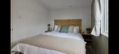 a bedroom with a white bed with a wooden headboard at Morsh Luxury Caravan Getaway in Colchester