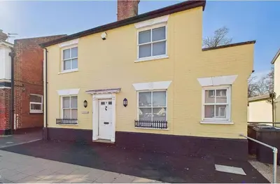 a yellow house with a white door and windows at Courtyards, 9 Mount street,Diss in Diss