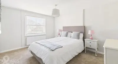 a white bedroom with a white bed and a window at Courtyards, 9 Mount street,Diss in Diss