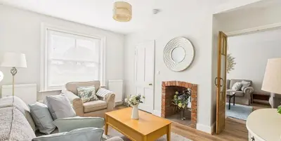 a living room with a couch and a fireplace at Courtyards, 9 Mount street,Diss in Diss