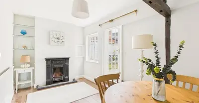 a living room with a wooden table and a fireplace at Courtyards, 9 Mount street,Diss in Diss