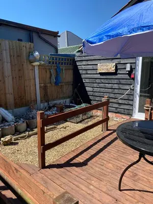 a wooden deck with a table and a fence at Oyster Lodge in West Mersea