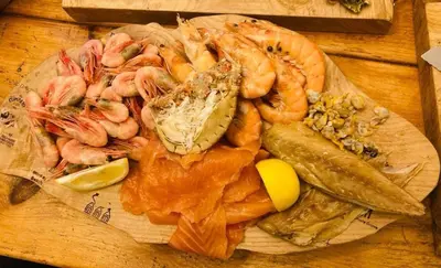 a plate of shrimp and other seafood on a table at Oyster Lodge in West Mersea