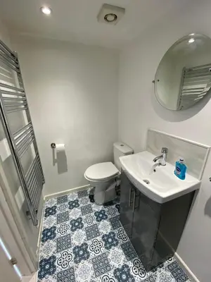 a bathroom with a toilet and a sink and a mirror at Oyster Lodge in West Mersea