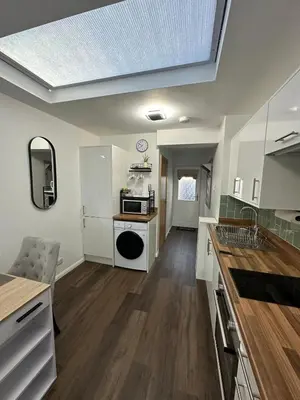 a kitchen with white cabinets and a skylight at Little side house in Cambridge in Trumpington