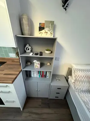 a book shelf in a bedroom with a bed at Little side house in Cambridge in Trumpington