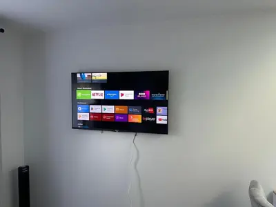 a flat screen tv hanging on a wall at Little side house in Cambridge in Trumpington