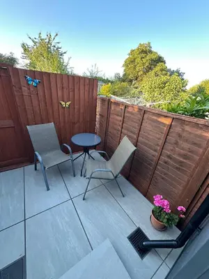 a patio with a table and chairs and a fence at Little side house in Cambridge in Trumpington
