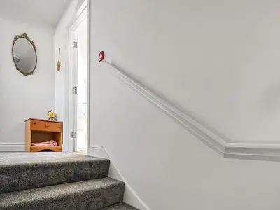 a stairway with a mirror on the wall at Moglett Cottage in Fincham
