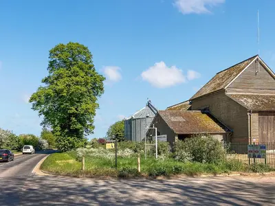 an old barn on the side of a road at Moglett Cottage in Fincham