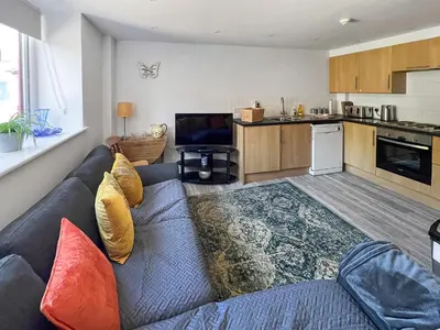 a living room with a couch and a kitchen at Moglett Cottage in Fincham