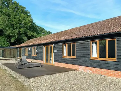 a black house with a wooden deck in front of it at Spring Vale Bungalow in Colchester