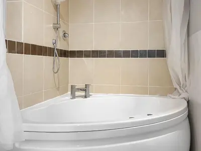 a bathroom with a bath tub and a toilet at Spring Vale Bungalow in Colchester