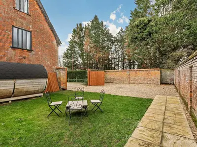 a yard with two chairs and a table in the grass at The Farmhouse - Uk48228 in Tibenham
