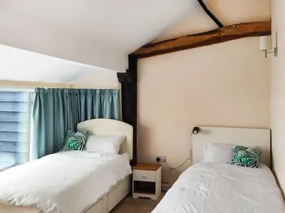 a bedroom with two beds next to a window at The Farmhouse - Uk48228 in Tibenham