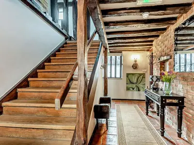 a staircase with a piano in a room with a brick wall at The Farmhouse - Uk48228 in Tibenham