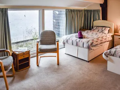 a bedroom with a bed and a chair and a window at The Pool House - Uk48229 in Tibenham