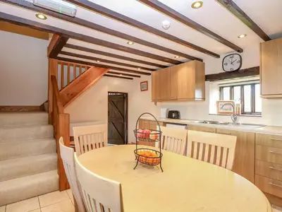 a kitchen with a table and chairs and a clock at Pond View Cottage - Uk48230 in Tibenham