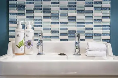 a bathroom sink with two faucets and towels at The Packhorse Inn in Newmarket