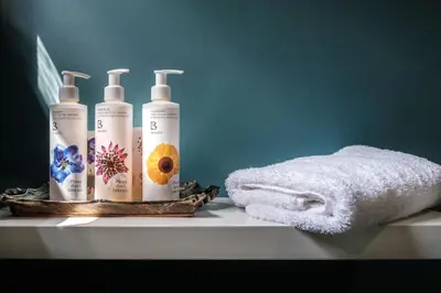 two bottles of shampoo and a towel on a shelf at The Packhorse Inn in Newmarket