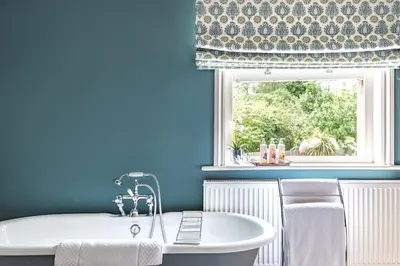 a bath tub in a bathroom with a window at The Packhorse Inn in Newmarket