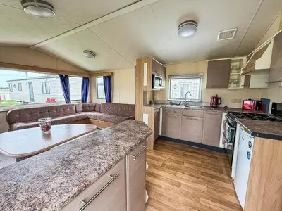 a kitchen and living room of a caravan at Great 8 Berth Caravan With Unlimited Wi-Fi At Seawick Holiday Park, Ref 27213Sw in Clacton-on-Sea