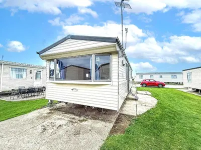 a tiny house is sitting in a yard at Great 8 Berth Caravan With Unlimited Wi-Fi At Seawick Holiday Park, Ref 27213Sw in Clacton-on-Sea