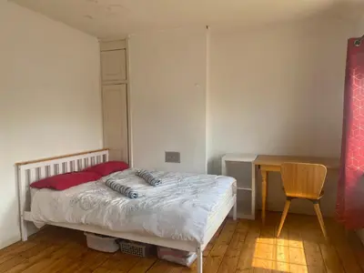 a small bedroom with a bed and a desk at Charlies House Newmarket - 3 bedroom in Newmarket