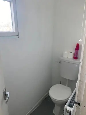 a white bathroom with a toilet and a window at Charlies House Newmarket - 3 bedroom in Newmarket