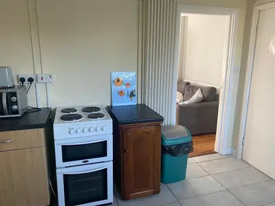 a kitchen with a stove and a kitchen with a couch at Charlies House Newmarket - 3 bedroom in Newmarket