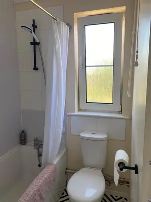 a bathroom with a toilet and a window and a tub at Charlies House Newmarket - 3 bedroom in Newmarket