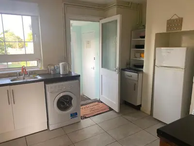 a kitchen with a washing machine and a refrigerator at Charlies House Newmarket - 3 bedroom in Newmarket