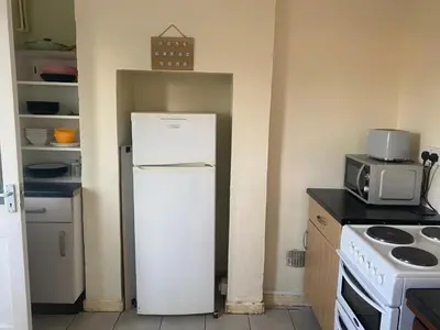 a small kitchen with a refrigerator and a microwave at Charlies House Newmarket - 3 bedroom in Newmarket