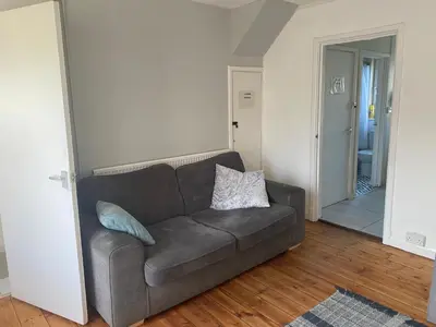 a living room with a brown couch and a hallway at Charlies House Newmarket - 3 bedroom in Newmarket