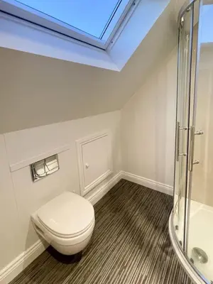 a bathroom with a toilet and a glass shower at Cosy Loft Retreat off Vibrant Mill Road - walk to station and City centre in Cambridge