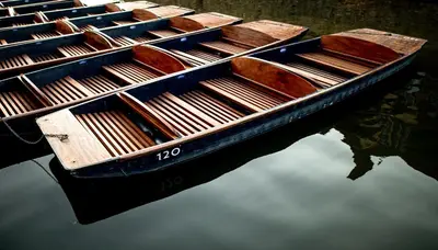 two wooden boats sitting in the water at Cosy Loft Retreat off Vibrant Mill Road - walk to station and City centre in Cambridge